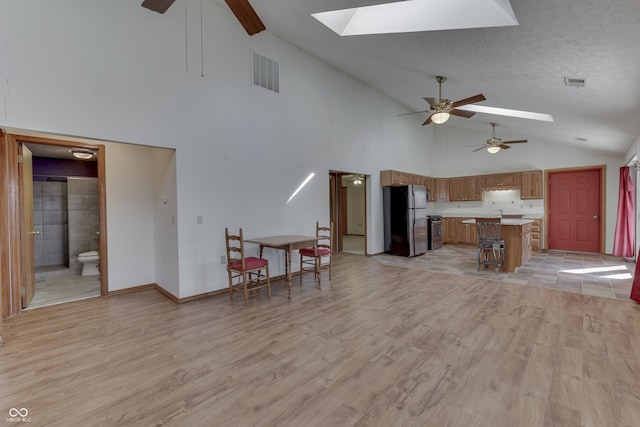 kitchen with visible vents, a skylight, light countertops, and freestanding refrigerator