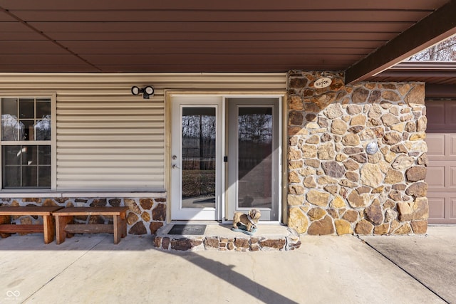 property entrance featuring stone siding