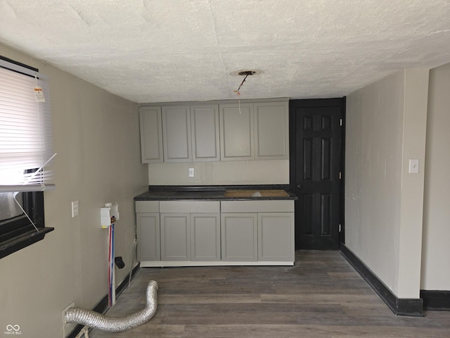 kitchen featuring baseboards, a textured ceiling, and dark wood-style floors