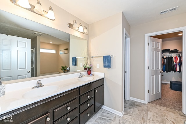 full bathroom with double vanity, visible vents, and a sink