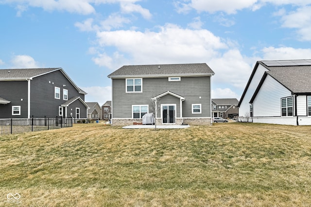 rear view of house with a patio, a lawn, and fence