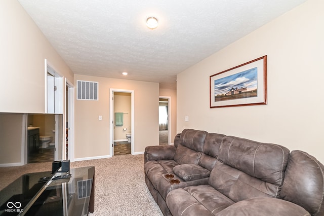 carpeted living room with visible vents, baseboards, and a textured ceiling