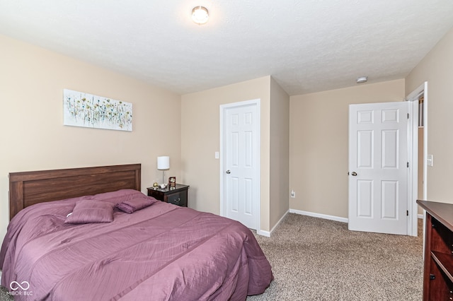 carpeted bedroom with baseboards and a textured ceiling