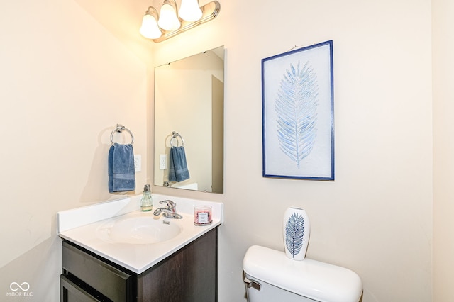 bathroom with vanity, a notable chandelier, and toilet