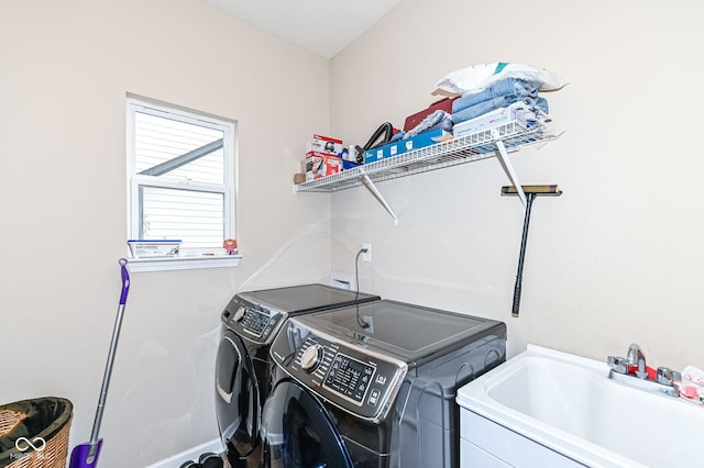 laundry room featuring laundry area, washing machine and dryer, and a sink