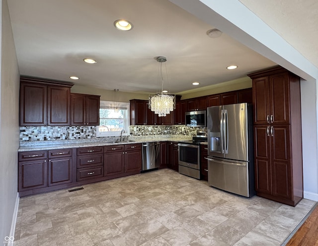 kitchen with decorative light fixtures, stainless steel appliances, backsplash, and dark brown cabinetry