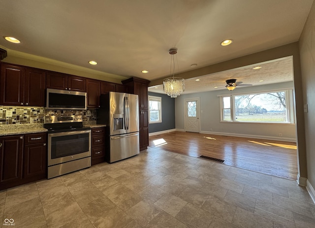 kitchen featuring baseboards, visible vents, dark brown cabinetry, appliances with stainless steel finishes, and tasteful backsplash