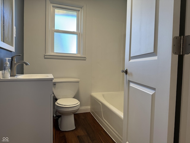 full bathroom with vanity, wood finished floors, baseboards, toilet, and a bathtub