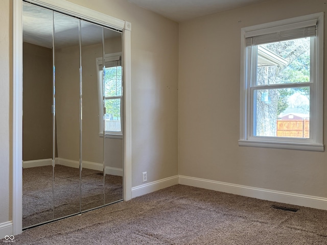 unfurnished bedroom featuring a closet, visible vents, baseboards, and carpet