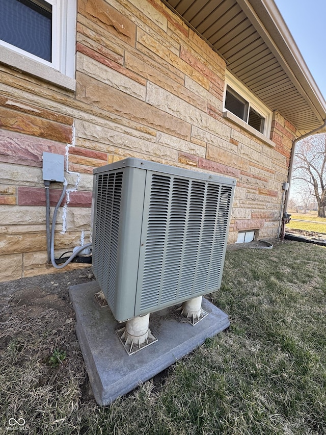 details with central air condition unit and brick siding