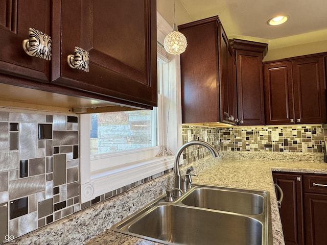 kitchen featuring a sink, decorative light fixtures, recessed lighting, decorative backsplash, and light stone countertops