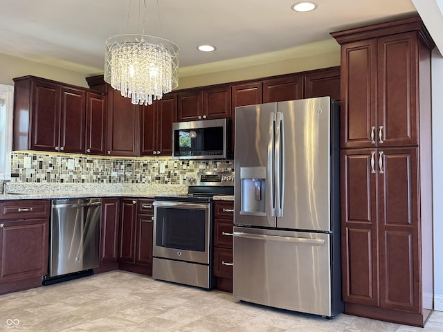 kitchen with light stone counters, a notable chandelier, appliances with stainless steel finishes, and decorative backsplash