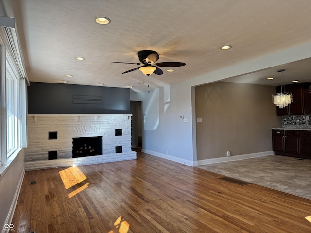 unfurnished living room featuring wood finished floors, a fireplace, and visible vents