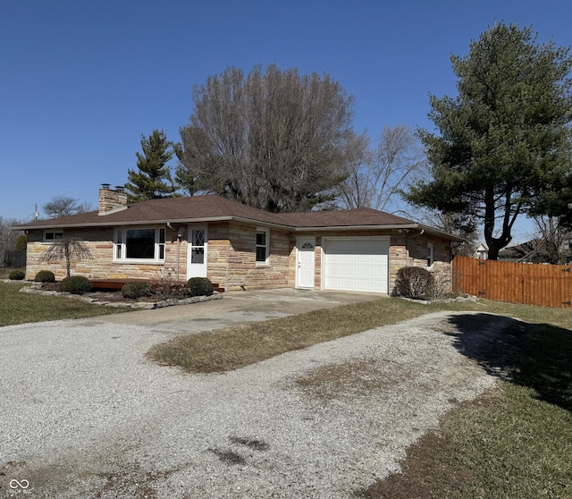 view of front facade with concrete driveway, fence, stone siding, and a chimney