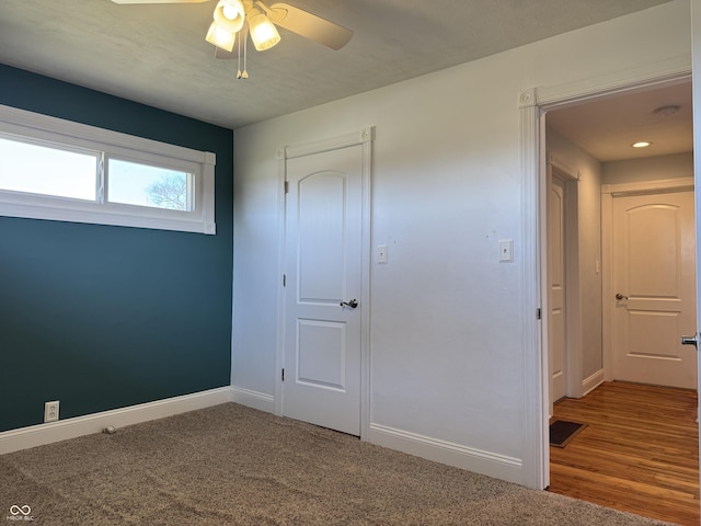 unfurnished bedroom featuring visible vents, baseboards, carpet, and ceiling fan