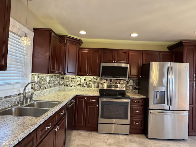 kitchen with a healthy amount of sunlight, a sink, stainless steel appliances, pendant lighting, and tasteful backsplash