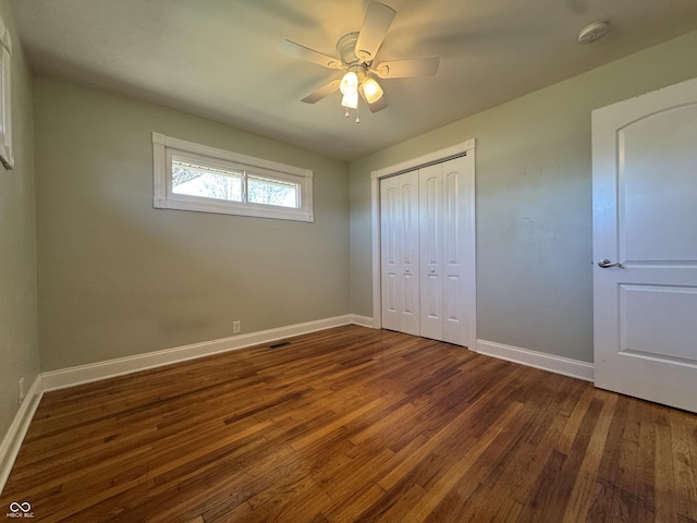 unfurnished bedroom with hardwood / wood-style flooring, baseboards, a closet, and ceiling fan