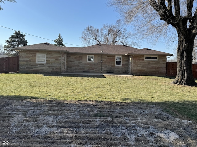 back of property with a patio, a yard, fence, and stone siding