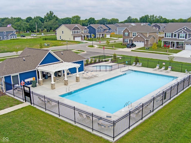 pool featuring a lawn, a pergola, a patio, fence, and a residential view