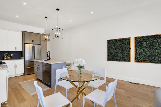 dining space with visible vents, baseboards, a chandelier, light wood-style flooring, and recessed lighting