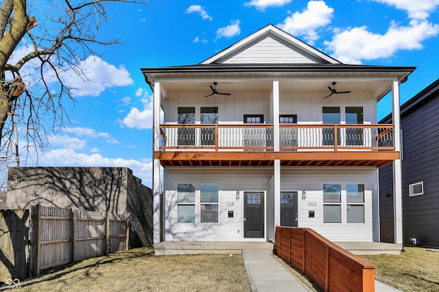 back of property with a yard, fence, board and batten siding, and ceiling fan