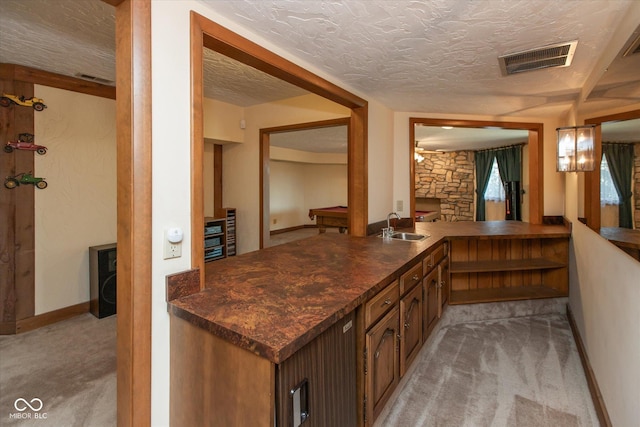 bar with baseboards, visible vents, a sink, a textured ceiling, and light carpet