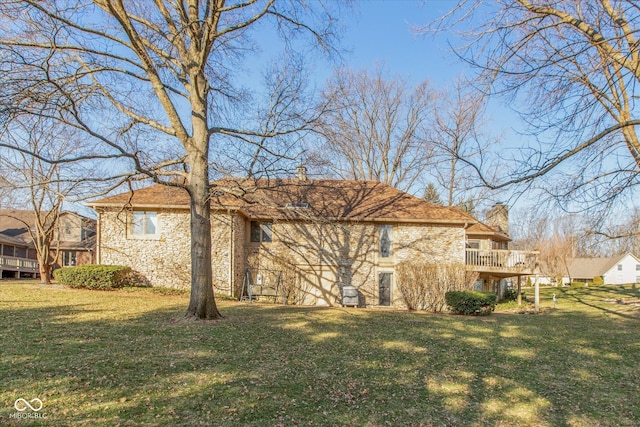 view of side of home with a yard, stone siding, and a deck