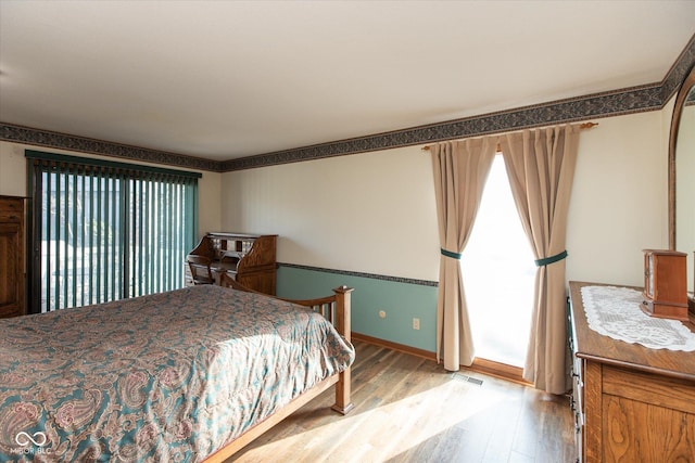 bedroom featuring visible vents, baseboards, and light wood-style flooring