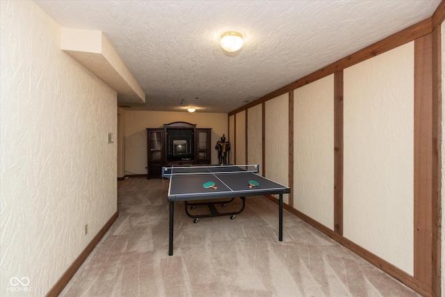 rec room with baseboards, a textured ceiling, carpet, and a textured wall