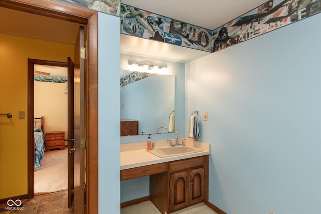 bathroom with baseboards, ensuite bath, and vanity