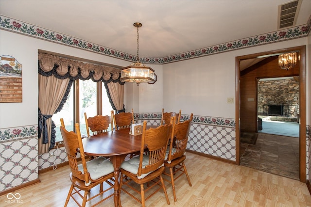 dining room with a notable chandelier, baseboards, light wood-type flooring, and visible vents