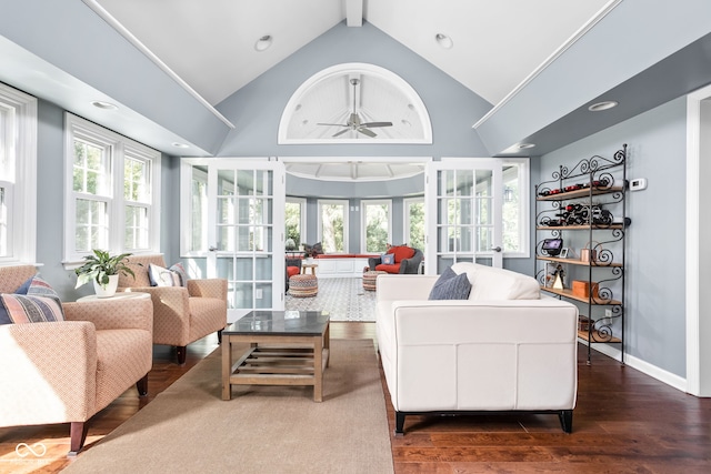 living area with ceiling fan, baseboards, beam ceiling, wood finished floors, and high vaulted ceiling