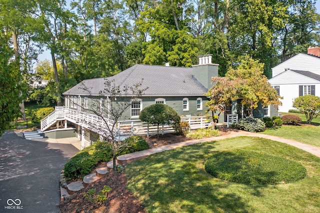 view of front of property with aphalt driveway, an attached garage, and a front yard