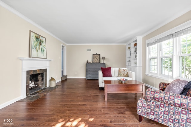 living area featuring visible vents, ornamental molding, wood finished floors, a fireplace, and baseboards