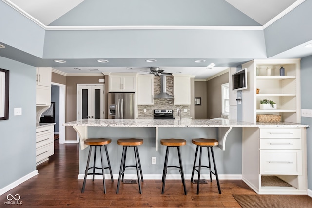 kitchen featuring a breakfast bar area, ornamental molding, a peninsula, stainless steel appliances, and white cabinetry