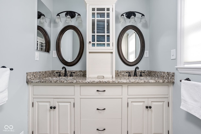 bathroom with a sink and double vanity