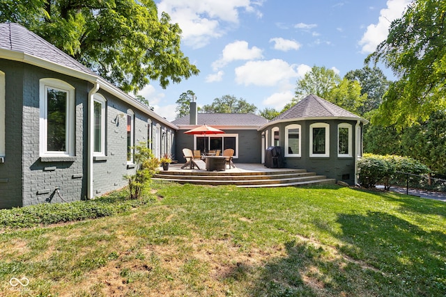 rear view of house with brick siding, crawl space, a lawn, and a gazebo