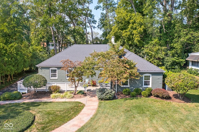 view of front of house with a patio, a front yard, and roof with shingles