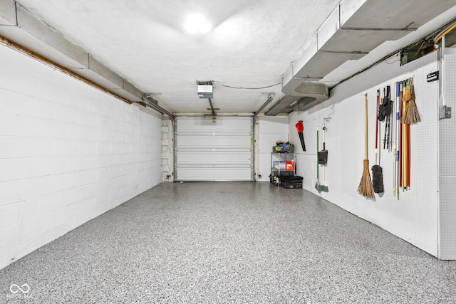 garage with concrete block wall and a garage door opener