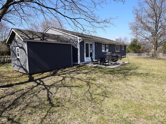 back of property with a patio area, a lawn, and fence