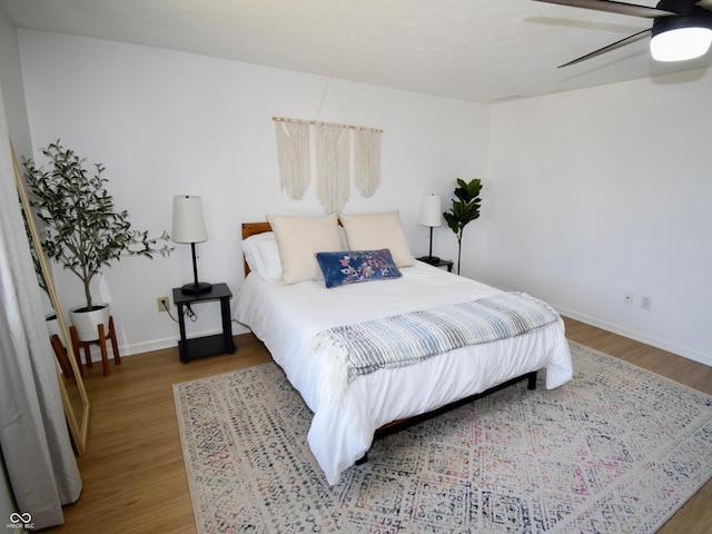 bedroom with wood finished floors, baseboards, and ceiling fan