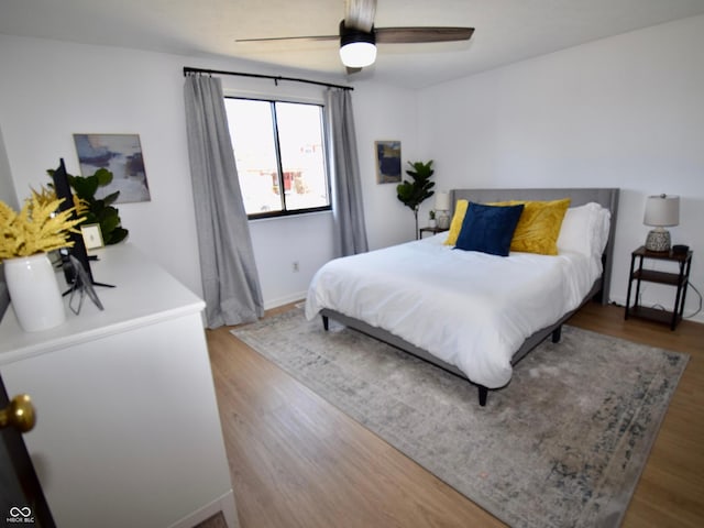 bedroom featuring a ceiling fan, wood finished floors, and baseboards