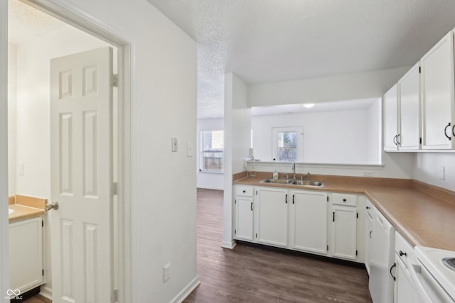 kitchen featuring a sink, a textured ceiling, white cabinetry, white appliances, and dark wood-style flooring