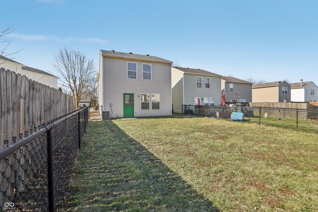 rear view of property featuring a residential view, a lawn, cooling unit, and a fenced backyard