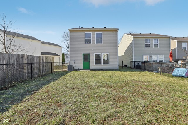 back of house with a yard, central AC, and a fenced backyard