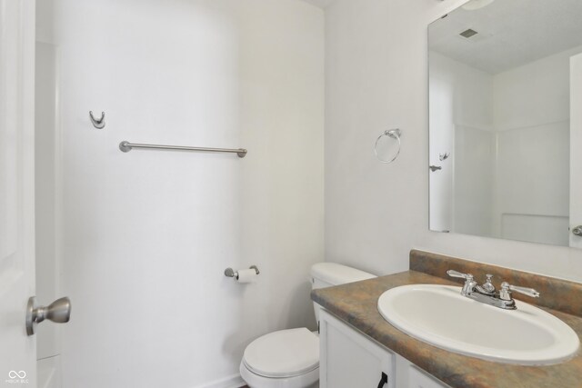 bathroom with visible vents, toilet, and vanity
