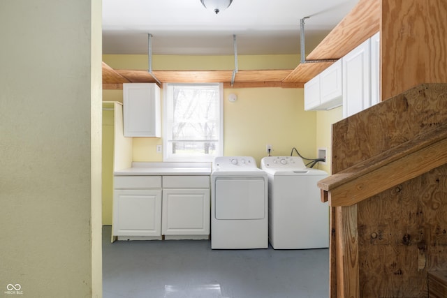 clothes washing area with washer and clothes dryer and cabinet space