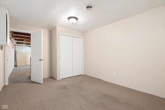unfurnished bedroom with a closet, visible vents, and light colored carpet