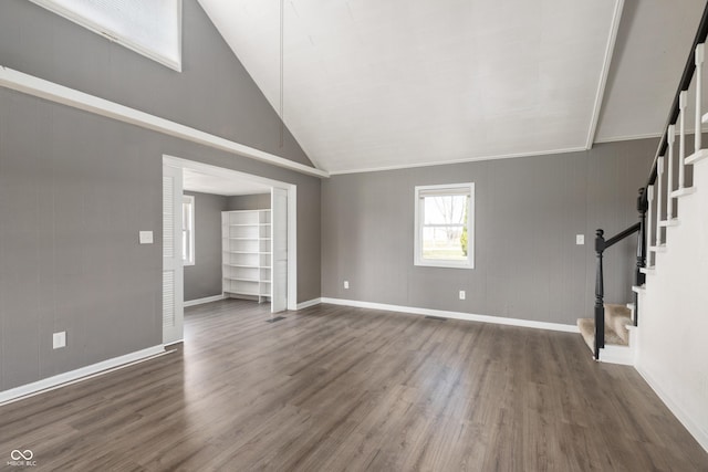 unfurnished living room with dark wood finished floors, stairway, high vaulted ceiling, and baseboards