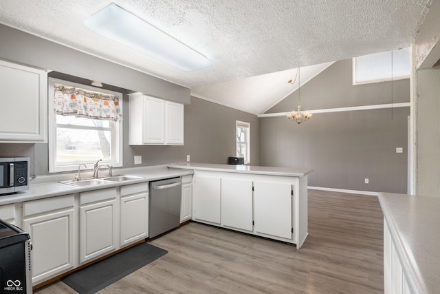 kitchen featuring a sink, lofted ceiling, appliances with stainless steel finishes, and light countertops